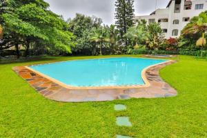 a swimming pool in a yard with grass and a building at Amazing Sea View Apartment La Ballito in Ballito