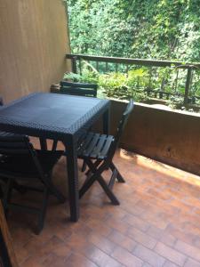 een zwarte tafel en stoelen op een patio bij casa del lago Lesa in Lesa