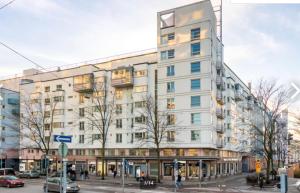 a large white building on the corner of a street at Scandinavian design heart City Center Runeberginkatu in Helsinki