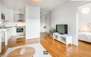 a white living room with a bed and a television at Scandinavian design heart City Center Runeberginkatu in Helsinki +25 photos