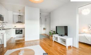 Sala de estar blanca con TV y cama en Scandinavian design heart City Center Runeberginkatu, en Helsinki