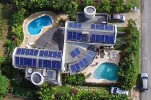 uma vista superior de um edifício com painéis solares sobre ele em Vida Mejor - Poolside em Saint James