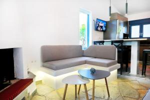 a living room with a couch and a table at Ariadni Villa Sani in Sani Beach