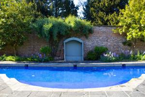 a brick building with a garage and a blue pool at Saltmarshe Hall in Saltmarshe