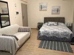 a bedroom with a bed and a couch at White Arches Modern Beautiful studio in Limassol