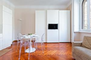 ein weißes Wohnzimmer mit einem Tisch und einem Sofa in der Unterkunft Porta Romana Cozy Studio in Mailand