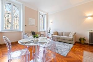 un soggiorno con tavolo, sedie e divano di Porta Romana Cozy Studio a Milano