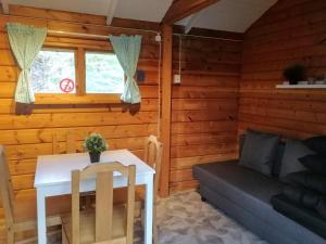 a living room with a table and a couch at Yxningens Holiday Homes, Cottages and Camping in Gusum +32 photos