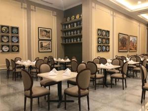 - une salle à manger avec des tables, des chaises et des serviettes dans l'établissement Mahkota Hotel Singkawang, à Singkawang