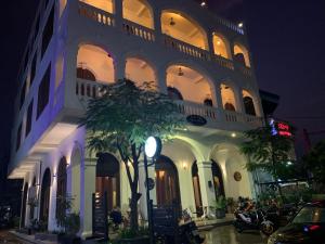 a building with a palm tree in front of it at The J Break Boutique in Kampot