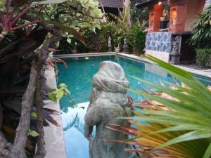 a statue in front of a swimming pool at The Sari Bungalows in Pemuteran