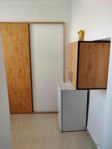 a kitchen with a door and a refrigerator and a cabinet at Sandor Apartment Calarasilor in Târgu-Mureş