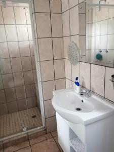 La salle de bains est pourvue d'un lavabo et d'une douche. dans l'établissement Eden Cottage, à White River