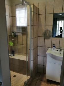 La salle de bains est pourvue d'une douche et d'un lavabo. dans l'établissement Eden Cottage, à White River