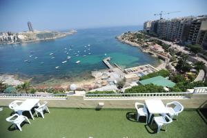a balcony with chairs and a view of the ocean at Carlton Hotel in Sliema