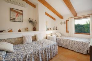 Dos camas en una habitación con ventana. en Ca Na Margalida, en Puerto Pollensa