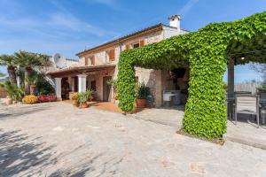 un arco cubierto de hiedra frente a una casa en Ca Na Margalida, en Puerto Pollensa