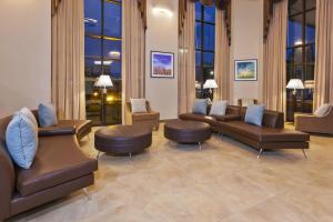 - une salle d'attente avec des canapés, des chaises et des fenêtres dans l'établissement Candlewood Suites Grand Rapids Airport, an IHG Hotel, à Grand Rapids