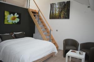 a bedroom with a bed and a spiral staircase at B&B Het Houten Paard in Ieper