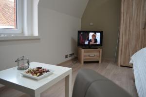 uma sala de estar com uma mesa branca e uma televisão em B&B Het Houten Paard em Ypres