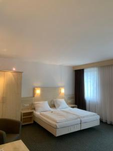 um quarto com uma cama grande e uma janela em Hotel Mondial Comfort - Frankfurt City Centre em Frankfurt