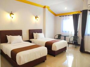a hotel room with two beds and a table at อันตงเพลส Anton place in Ban Pa Ngiu
