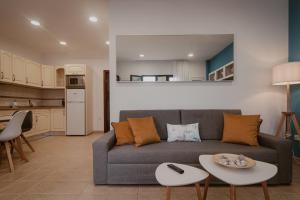 a living room with a couch and a kitchen at La Pardela Experience Apartamentos in Caleta de Sebo