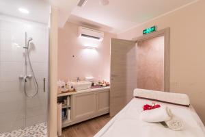 ein Badezimmer mit einem Bett, einer Dusche und einem Waschbecken in der Unterkunft Family Resort del Mar in Pula