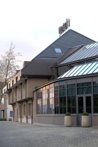 un edificio con muchas ventanas en una calle en Hotel Falko, en Meise