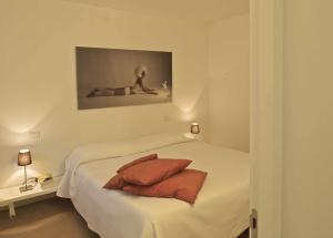 a white bedroom with a bed with two pillows at Casa Ester in Feltre
