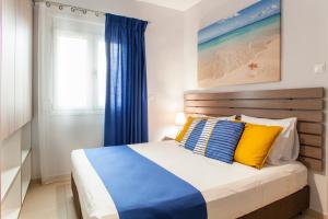 a bedroom with a bed with blue and yellow pillows at Konstantinos Villa in Koutsourás