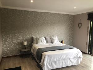 a bedroom with a large bed with white sheets at Number Six in Durban