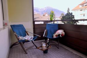 two blue chairs sitting on a balcony with a window at Appartamento Grunwald in Brunico