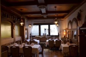 a dining room with tables and chairs with white table cloth at Hotel Restaurant Lamm in Mönsheim