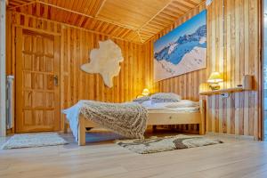 ブコビナ・タトシャンスカにあるApartamenty i pokoje Pod Limbami - sauna, tężniaの木製の部屋にベッド1台が備わるベッドルーム1室があります。