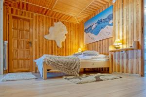 a bedroom with a bed in a wooden room at Apartamenty i pokoje Pod Limbami - sauna, tężnia in Bukowina Tatrzańska