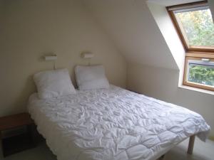 a white bed in a room with a window at Condor 19 in Nieuwpoort