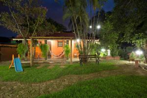 uma casa com um parque infantil e um baloiço à noite em Pousada Alta Vista - Inhotim em Brumadinho