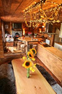 a kitchen with a table with a vase of flowers on it at Snowy River Lodge in Aviemore