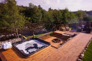 a hot tub sitting on top of a wooden deck at Snowy River Lodge in Aviemore