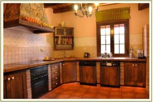 una grande cucina con armadi in legno ed elettrodomestici di VILLA LOS MELLIZOS a Ronda