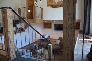 a living room with a staircase with a chair and a table at Am Krummbach in Isny im Allgäu