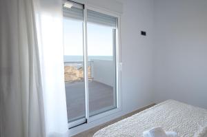 a bedroom with a window with a view of the ocean at Vistamar 1 in Oliva