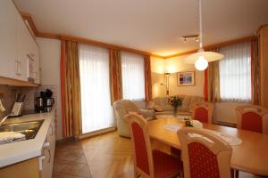 Una cocina y una sala de estar con mesa y sillas. en Apartment Sonnenblume Kusenberg, en Schladming 3 fotos más