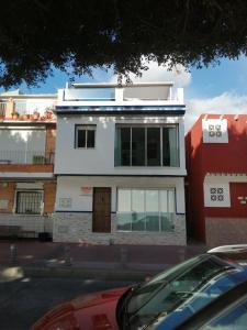 a white building with windows on a street at Apartment on the beach in Málaga