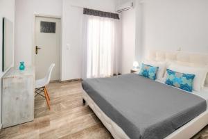 a bedroom with a large bed and a desk at Villa Kavallaris & Apartments in Mesaria