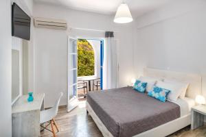 a bedroom with a bed and a table and a window at Villa Kavallaris & Apartments in Mesaria