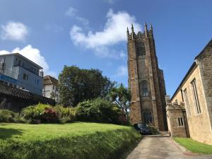 een kerk met een klokkentoren in het midden van een tuin bij The Quies in Newquay