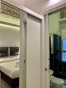 sypialnia z łóżkiem oraz łazienka z lustrem w obiekcie Luxury rooms near Colosseum w Rzymie
