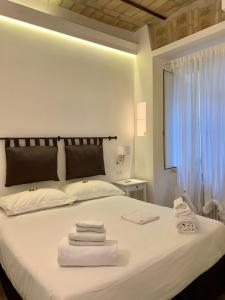 sypialnia z białym łóżkiem i ręcznikami w obiekcie Luxury rooms near Colosseum w Rzymie